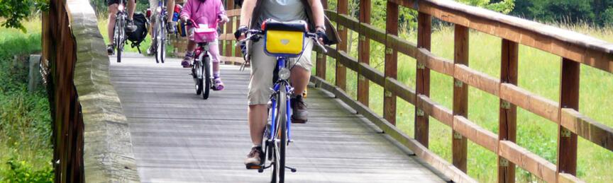 Radfahrer auf einer Holzbrücke. Foto: Kolberg-Café