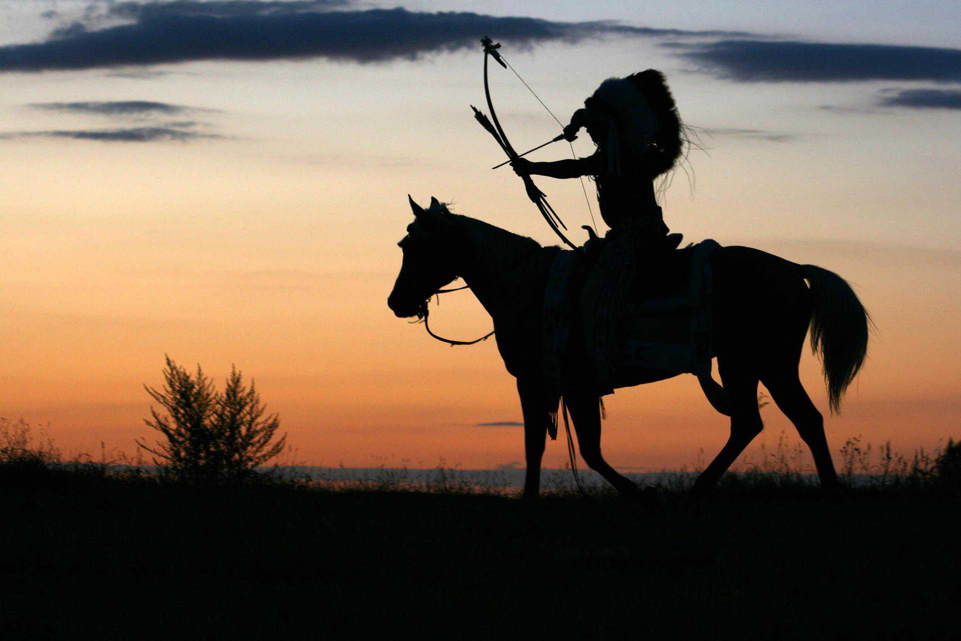 Western-Show-Motiv, Reiter auf einem Pferd mit Bogen im Sonnenuntergang. Foto:Tomasz Proszek via Pixabay