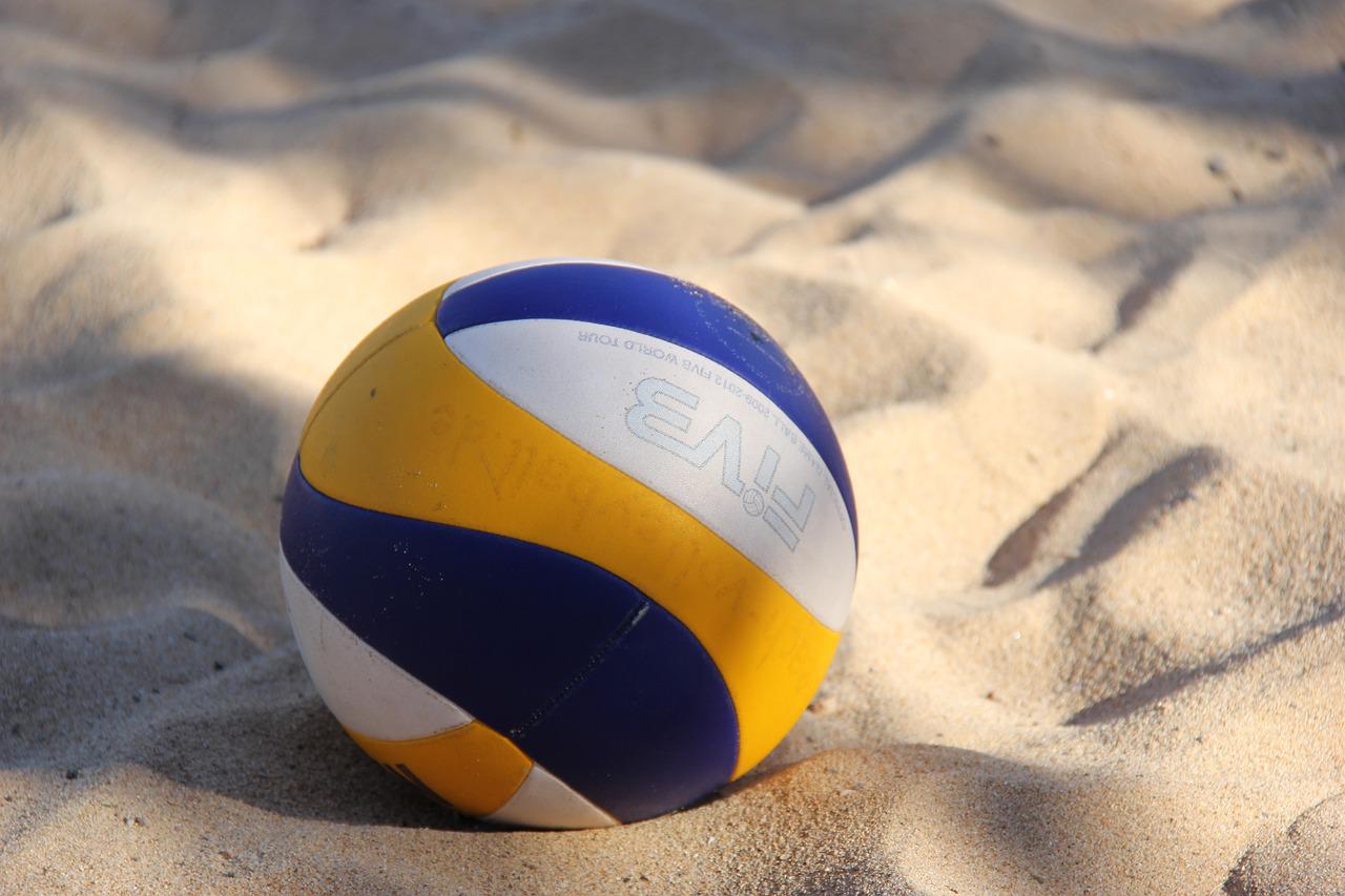 Ein Volleyball liegt im Sand in der Sonne. Foto: Wolfgang Gerth via Pixabay
